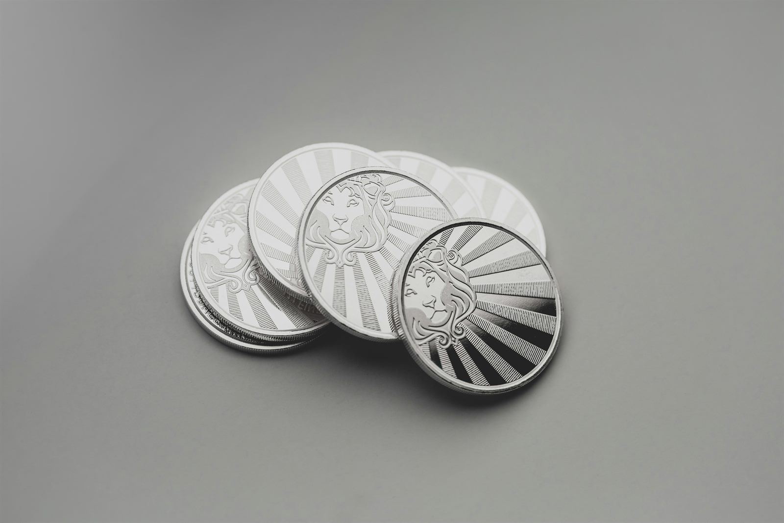 Stack of .999 fine silver rounds fanned on a light surface.